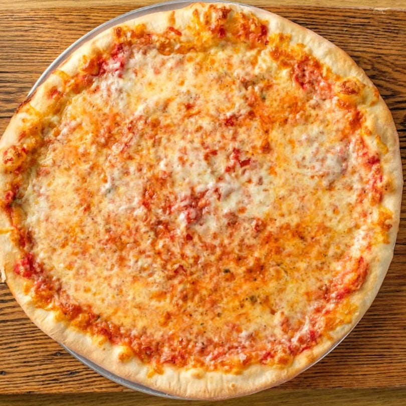 A large, cheesy Delicias Sobre Ruedas pizza with a golden crust on a wooden table.